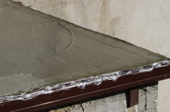 Na styku balkónu a stěny vlepíme do první vrstvy hydroizolační stěrky těsnící pás KLASIK a potom ho překryjeme druhou vrstvou stěrky.